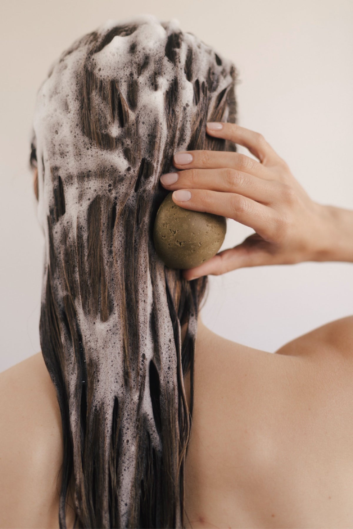 Vaste shampoo van Homnès aangebracht op het haar